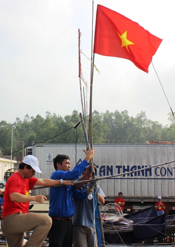 Đồng chí Cao Lê Tùng Nghĩa – Phó Bí thư Tỉnh đoàn gắn lá cờ Tổ quốc trên tàu cá của ngư dân huyện đảo Lý Sơn